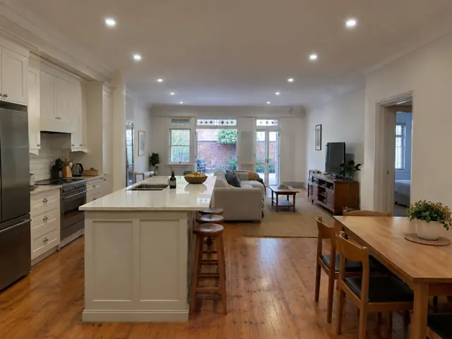 Ceiling downlights in a bright open-plan kitchen and living room with timber floors in Maroubra